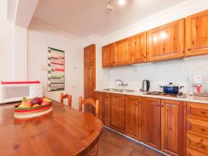 una cocina con una mesa de madera y un bol de fruta. en Apartment Melis-II - 4 by Interhome, en Pals