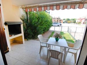 un patio con tavolo e sedie e un balcone. di Apartment Hermitage-2 by Interhome a Marina di Santa Croce