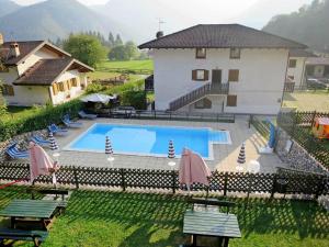 a large swimming pool in front of a house at Apartment Dromaè-2 by Interhome in Mezzolago