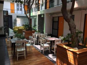 a restaurant with tables and chairs and a tree at Mini Loft Buenavista 106 in Mexico City