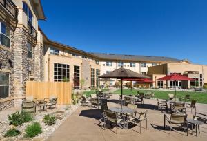 een patio met tafels en stoelen en een gebouw bij ClubHouse Hotel and Suites in Pierre