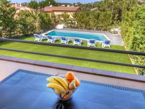 een fruitschaal op een tafel naast een zwembad bij Holiday Home Costabella by Interhome in Caulés