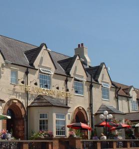 un bâtiment avec un panneau à l'avant dans l'établissement Unicorn, Gunthorpe by Marston's Inns, à Lowdham