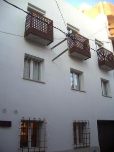 a white building with windows and balconies on it at Apartamentos Can Quim in L'Escala
