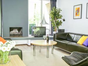 ロヘムにあるHoliday Home Bosrijk Ruighenrode-3 by Interhomeのリビングルーム(黒い革張りのソファ、テーブル付)