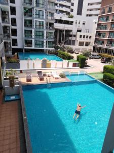 un hombre nadando en una piscina en un edificio en Neo Condo Pattaya A709 A209, en Jomtien Beach