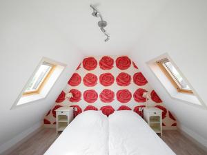 1 dormitorio con rosas rojas en la pared en Holiday Home Wiringherlant-5 by Interhome, en Noordstroe