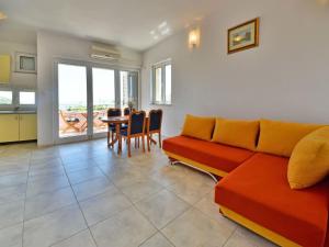 a living room with a couch and a table with chairs at Apartment Golub-4 by Interhome in Cesarica