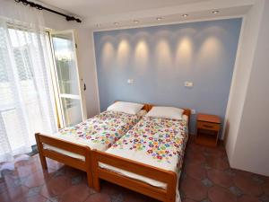 a bedroom with a large bed with a colorful comforter at Apartment Dada-2 by Interhome in Omišalj