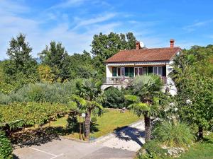 a house with palm trees in front of a garden at Holiday Home Jelka by Interhome in Njivice