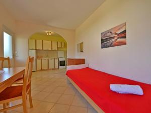 a bedroom with a red bed and a dining table at Holiday Home Franjo-2 by Interhome in Ika
