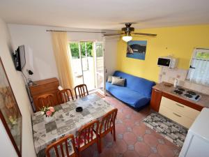a living room with a table and a blue couch at Apartment Dada-2 by Interhome in Omišalj