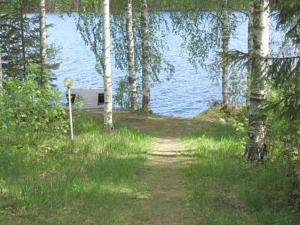 a path leading to a house by the water at Holiday Home Pellervo by Interhome in Kurkimaki