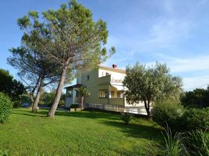 a house with a tree in the yard at Apartment Dada-2 by Interhome in Omišalj