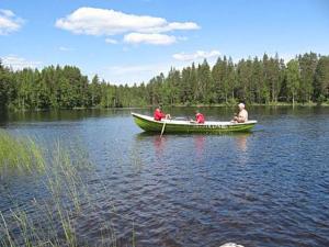 a group of people in a boat on a lake at Holiday Home Mielikki by Interhome in Kurkimaki