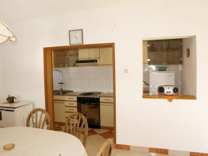 uma pequena cozinha com mesa e bancada em Apartment Agneza by Interhome em Brgulje
