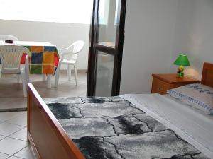 Schlafzimmer mit einem Bett, einem Tisch und Stühlen in der Unterkunft Apartment Zdenko-3 by Interhome in Kali