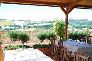 una mesa con manteles y sillas blancas y vistas en Locanda I Piceni, en Ortezzano
