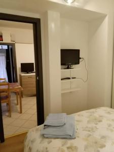 1 dormitorio con 1 cama y TV en la pared en Beautiful Lake Como Bilocale, en Blevio