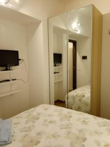 1 dormitorio con espejo, 1 cama y TV en Beautiful Lake Como Bilocale, en Blevio