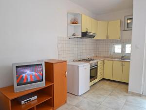 a small kitchen with a tv on a table at Apartment Golub-2 by Interhome in Cesarica +12 photos