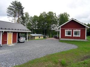 Kurkimaki的住宿－Holiday Home Talvikki by Interhome，车道旁的红色房子,有车停放