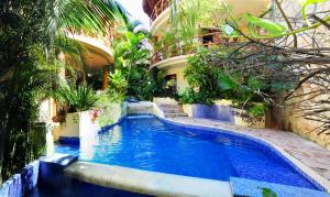 uma piscina no meio de um edifício com plantas em Villas Sacbe Condo Hotel and Beach Club em Playa del Carmen