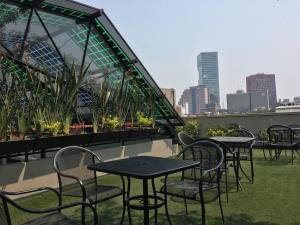 a row of tables and chairs on the roof of a building at Mini Loft Buenavista 106 in Mexico City