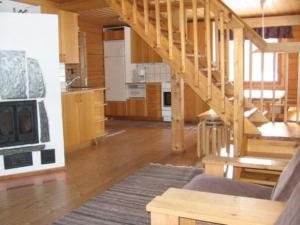 a living room with a staircase and a kitchen at Holiday Home Pellervo by Interhome in Kurkimaki