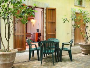 einen Tisch und Stühle in einem Zimmer mit Bäumen in der Unterkunft Apartment Montecorneo-1 by Interhome in Montebello