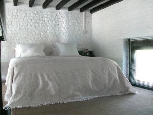 een slaapkamer met een wit bed met witte lakens en een raam bij Apartment Holly Lodge Coach House by Interhome in Londen