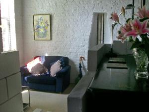- un salon avec un canapé bleu et un vase de fleurs dans l'établissement Apartment Holly Lodge Coach House by Interhome, à Londres