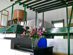 een vaas met roze bloemen op een tafel naast een stapelbed bij Apartment Holly Lodge Coach House by Interhome in Londen