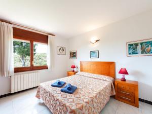 1 dormitorio con 1 cama con 2 toallas azules en Holiday Home Mas Vila by Interhome, en Sant Antoni de Calonge