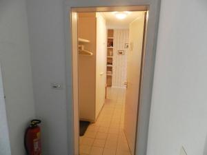 um corredor com uma porta que conduz a uma cozinha com uma boca de incêndio em Apartment Suzanne Nr- 20 by Interhome em Gstaad