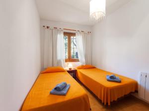 カロンジェにあるHoliday Home Sansu by Interhomeのオレンジのシーツが備わる客室内のベッド2台