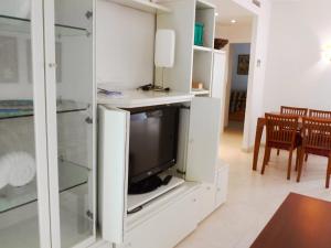 ein Wohnzimmer mit einem TV in einem weißen Schrank in der Unterkunft Apartment Las Dunas-4 by Interhome in Denia