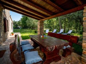 an outdoor patio with a wooden table and chairs at Holiday Home Tommy by Interhome in Gedići