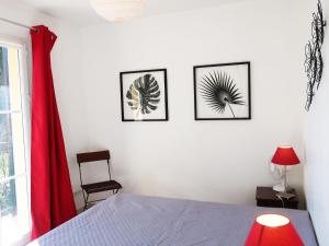 コゴランにあるApartment La Boisseliere by Interhomeの壁に3枚の写真が飾られたベッドルーム、ベッド1台が備わるベッドルーム1室