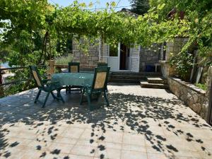 a patio with a table and chairs under a tree at Holiday Home Ratimir by Interhome in Rogač