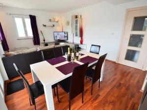 a dining room with a white table and black chairs at Apartment Šverko by Interhome in Trget