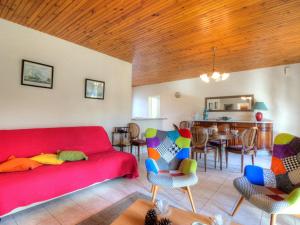 uma sala de estar com um sofá vermelho e cadeiras em Holiday Home Les Vignes Océanes by Interhome em Capbreton