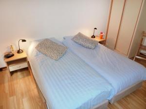 a bedroom with a bed with blue sheets and two lamps at Holiday Home 2-1 by Interhome in Lochem