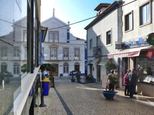 a group of people walking down a street with buildings at Studio Studio Ericeira by Interhome in Ericeira +10 photos