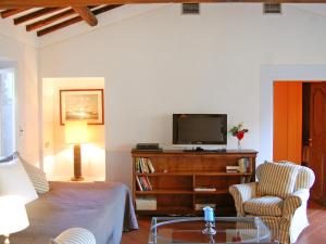 a living room with a tv and a chair and a table at Apartment Campo de' Fiori Bright by Interhome in Rome