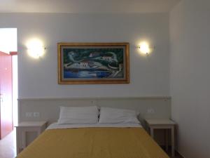 a bedroom with a bed with a picture on the wall at Affittacamere Villa Brazzano in Scalea