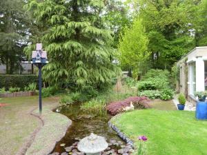 a garden with a pond and a bird bath in the yard at Holiday Home 2-1 by Interhome in Lochem