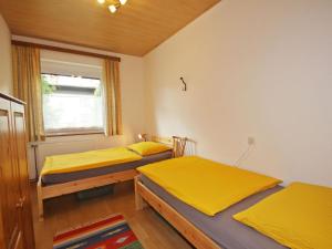 two beds in a room with yellow sheets at Apartment Annemarie by Interhome in Glanz