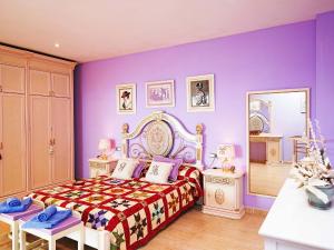 リョレート・デ・マルにあるVilla Adelaida by Interhomeの紫の壁のベッドルーム(ベッド1台、鏡付)