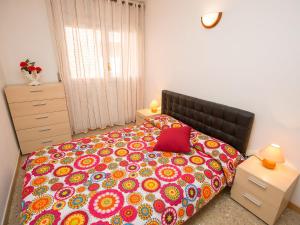 1 dormitorio con 1 cama grande y colcha colorida en Apartment Rambla de Tossa by Interhome, en Tossa de Mar